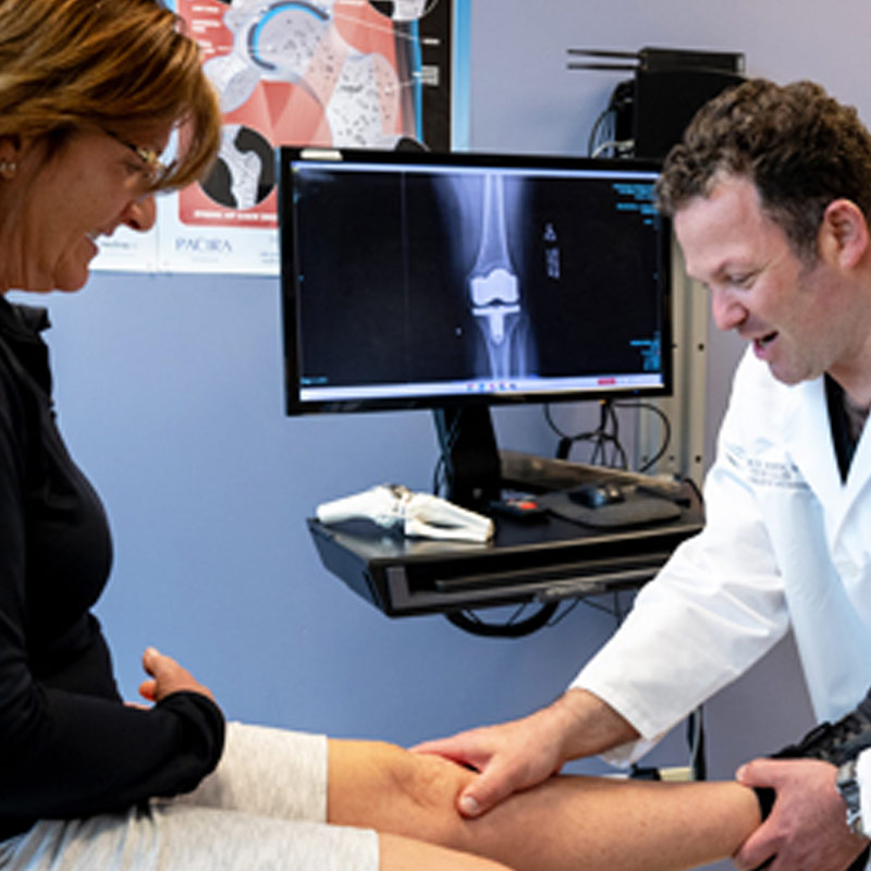 Orthopedic doctor examining a female patients knee