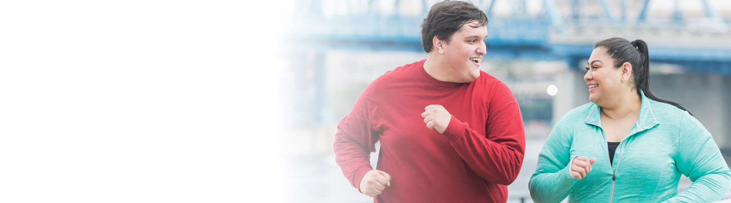Man in a red shirt and a woman in a blue athletic shirt on a run together