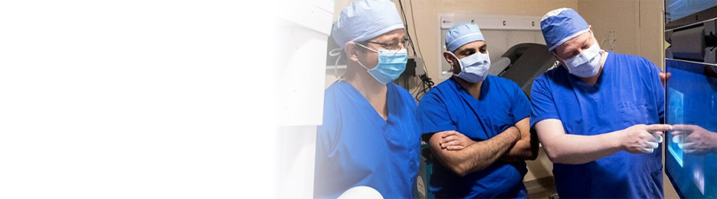 three thoracic surgeons looking at a screen