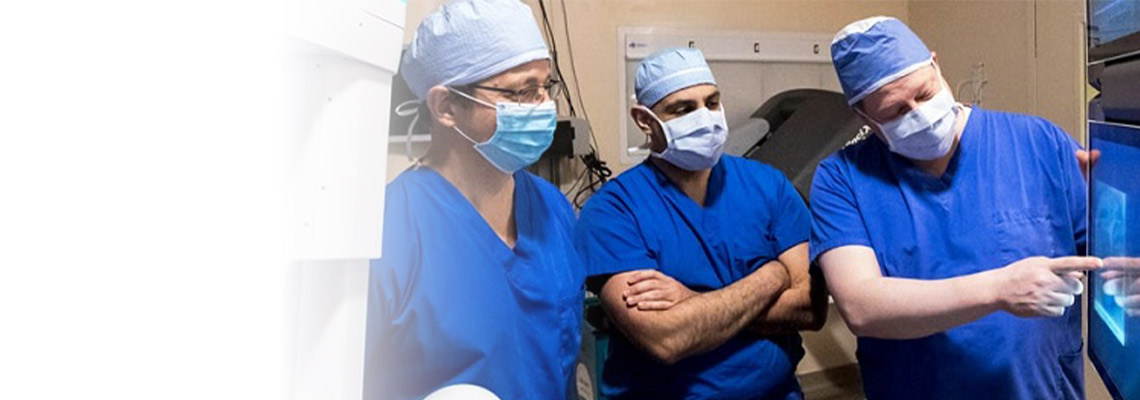 three thoracic surgeons looking at a screen