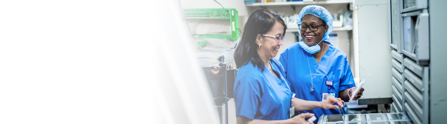 Two female pharmacists talking while sorting pills