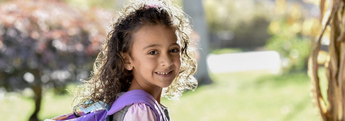Little girl smiling with backpack