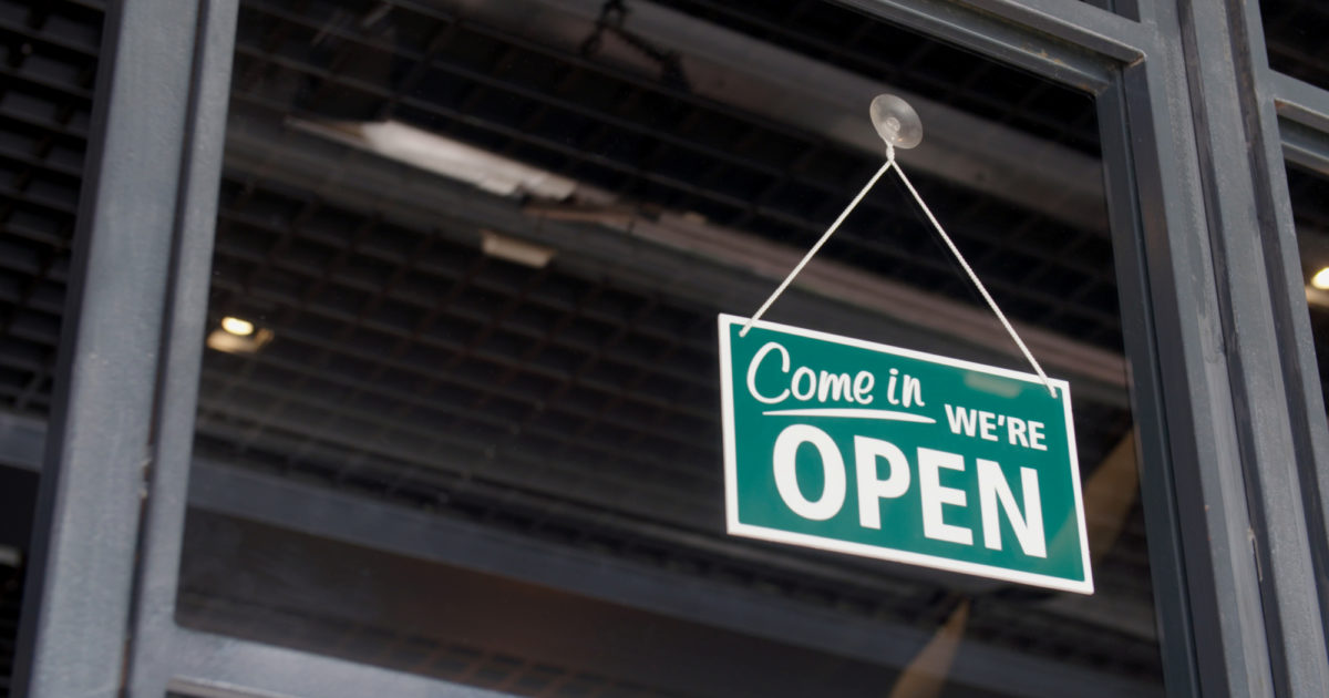 "Come in we're open" sign hanging on a door
