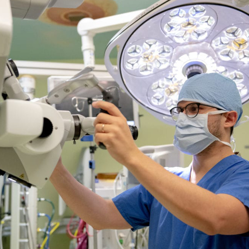 Technician operating a machine for pediatric neurosurgery unit