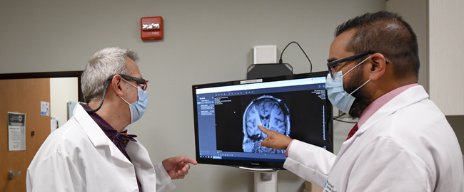 two physicians looking at a scan of a brain