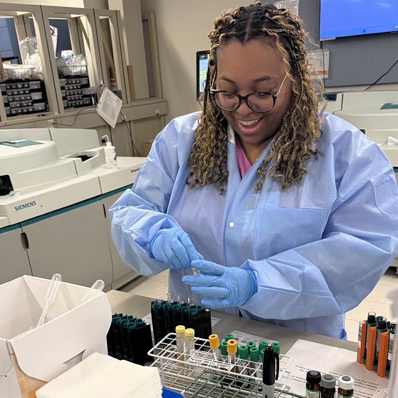 Female student wearing protective gear in the lab.