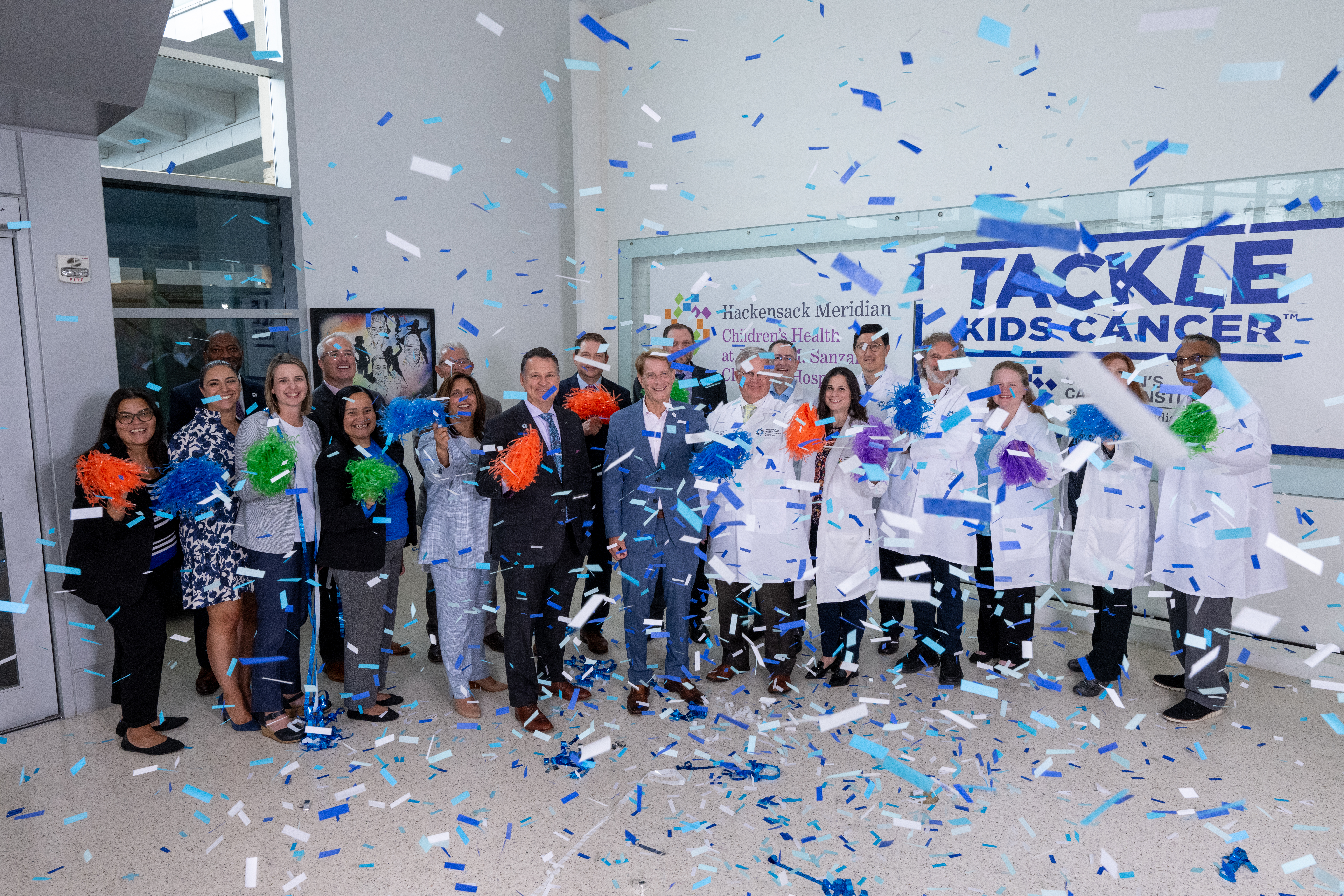 A group of physicians celebrating with confetti and and pom poms.