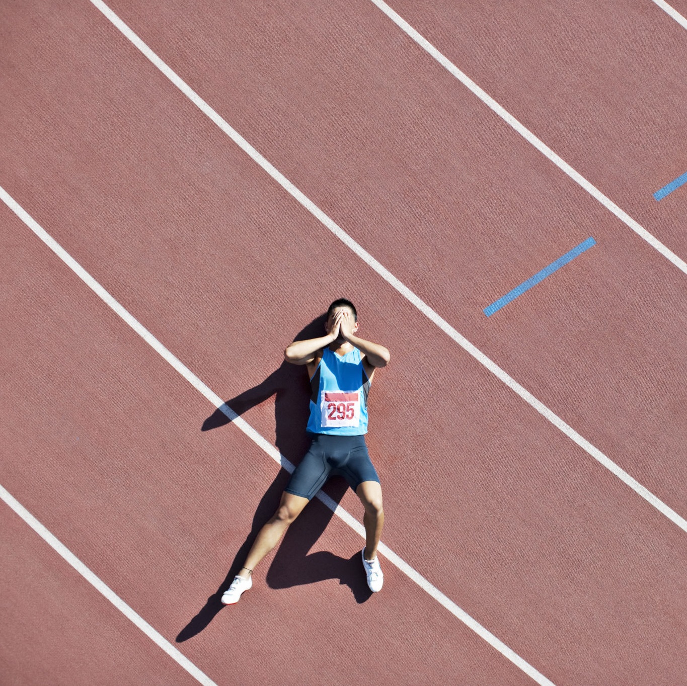 person laying on a track after running
