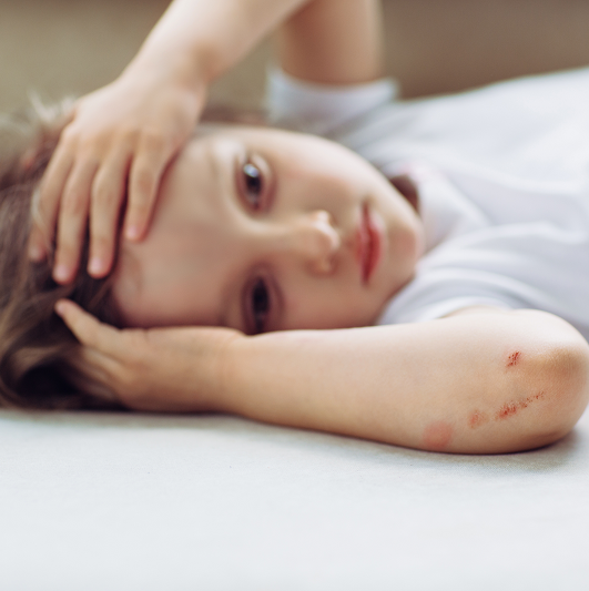 Child holding their head from injury, potentially a concussion