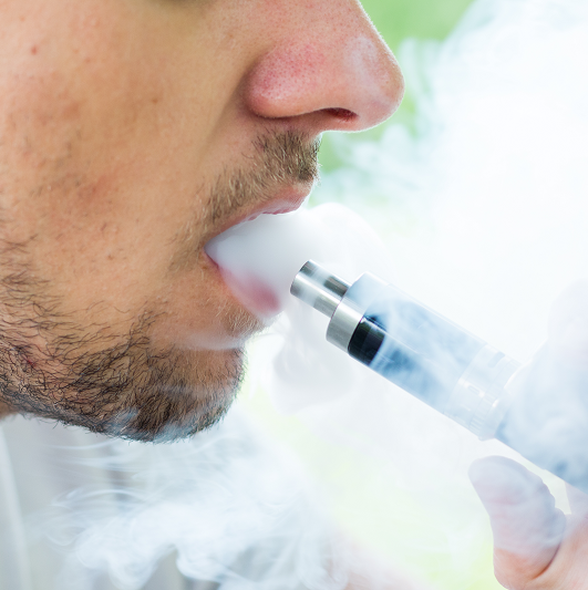 Close up of a man vaping an e-cigarette.
