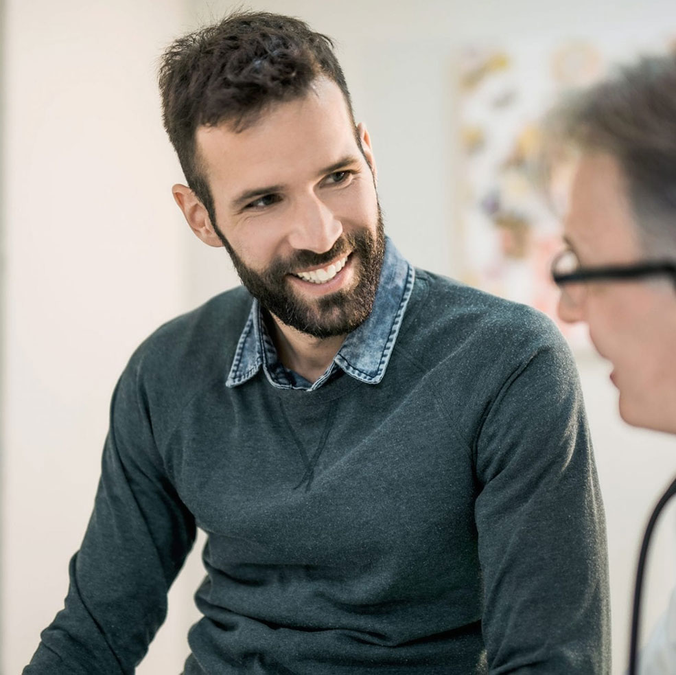 Young man speaking with his doctor about prostate cancer.