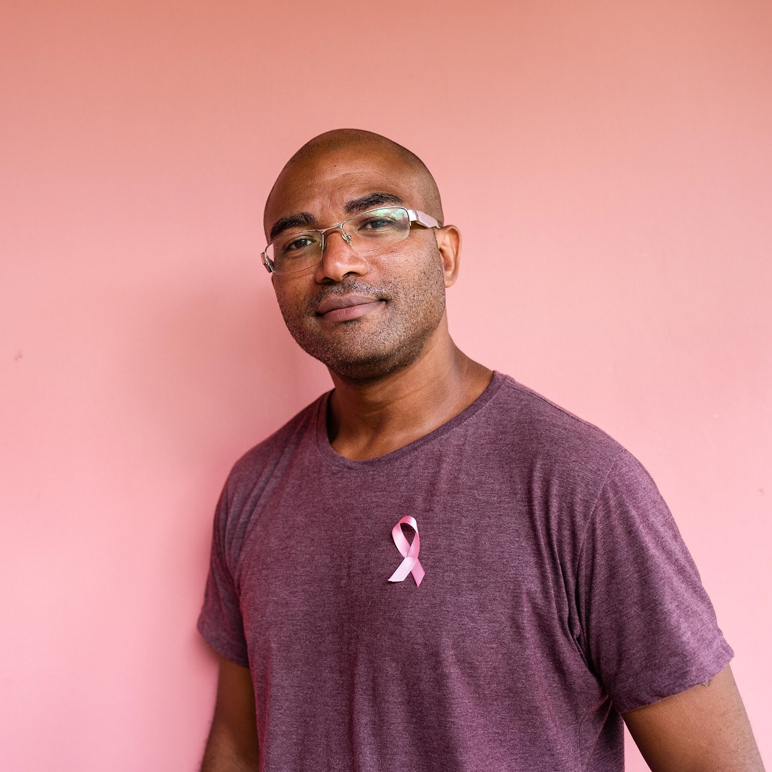 black male wearing a breast cancer awareness ribbon