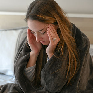 woman in bed with a headache