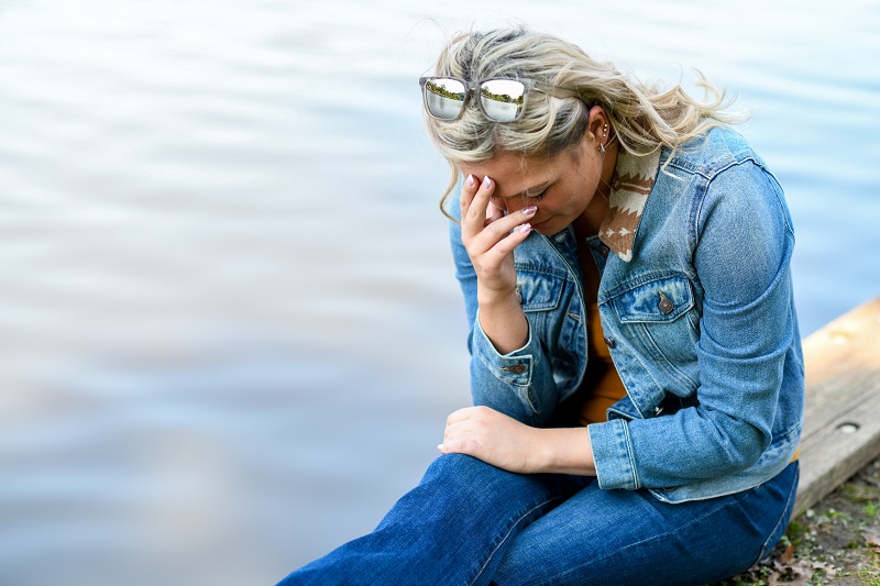 Young woman dealing with the mental health impact of long COVID; sad and anxious