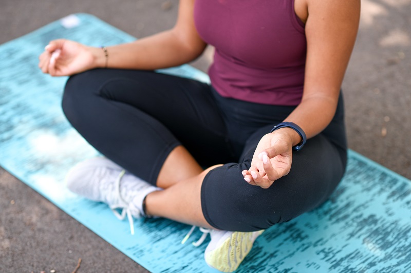 Young woman enjoying meditation outside.