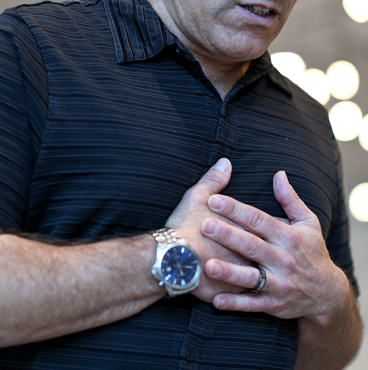 Man clenching his chest from heart failure and chest pain