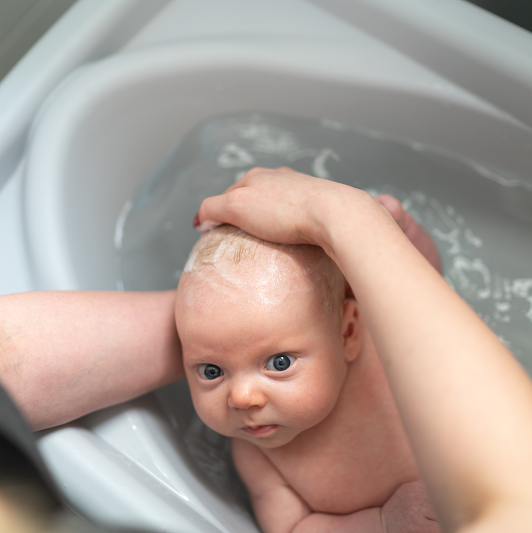 washing a small infant in a bath