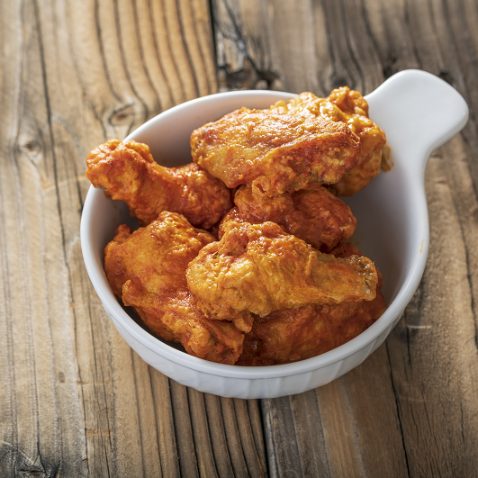 buffalo air fried chicken in a bowl on a table