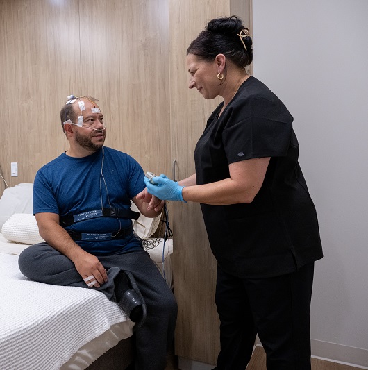 Sleep center technician helping the patient get set up for a sleep study.