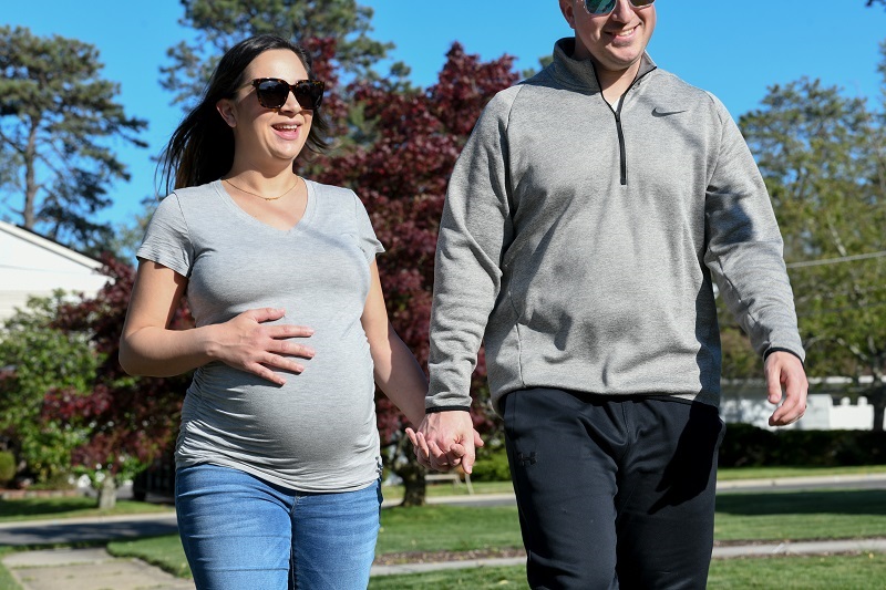 Husband and pregnant wife taking a walk to exercise.