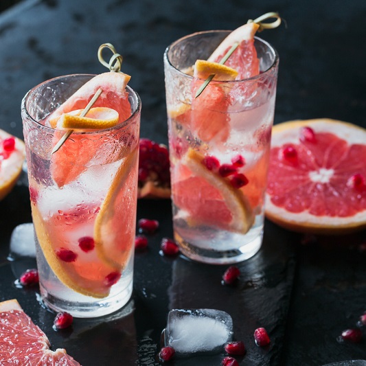 Grapefruit and pomegranate mocktail, refreshing summer drink with crushed ice and sparkling water
