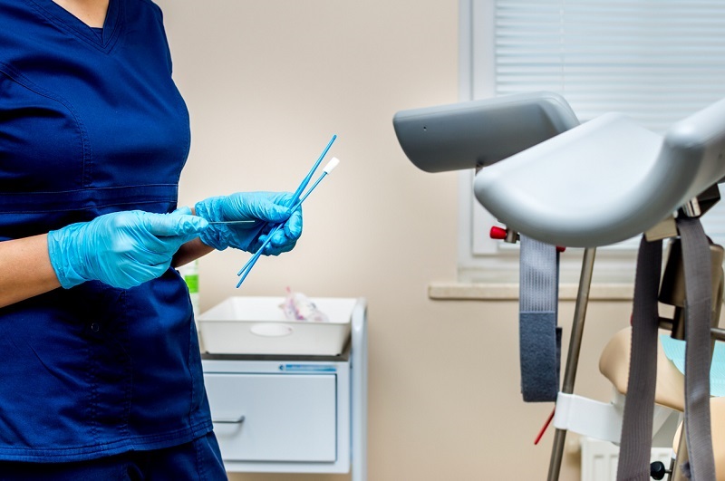 Gynecologist holds instruments for taking a pap smear. In the OBGYN office.