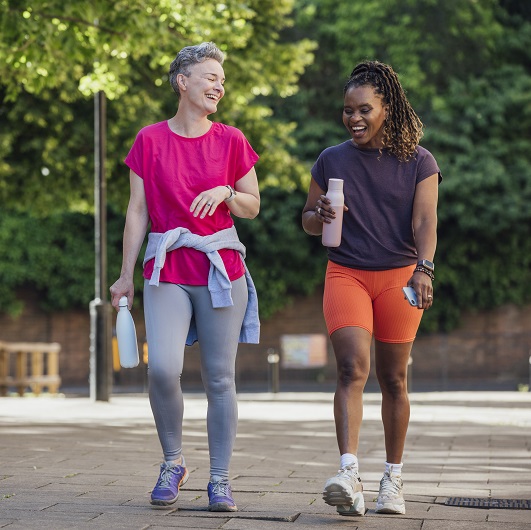 Two women smiling and walking.