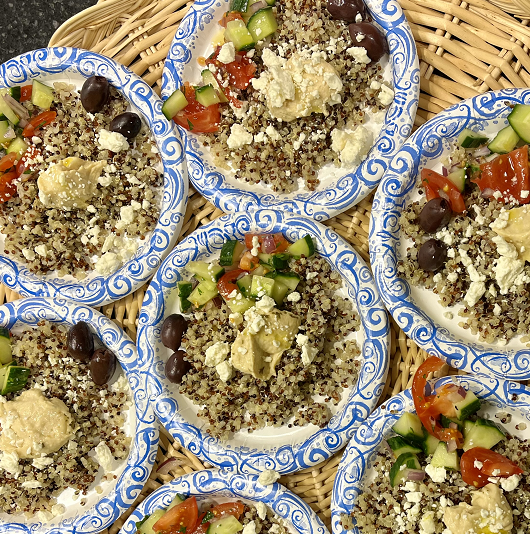 A bunch of servings of a Mediterranean grain bowl on display.
