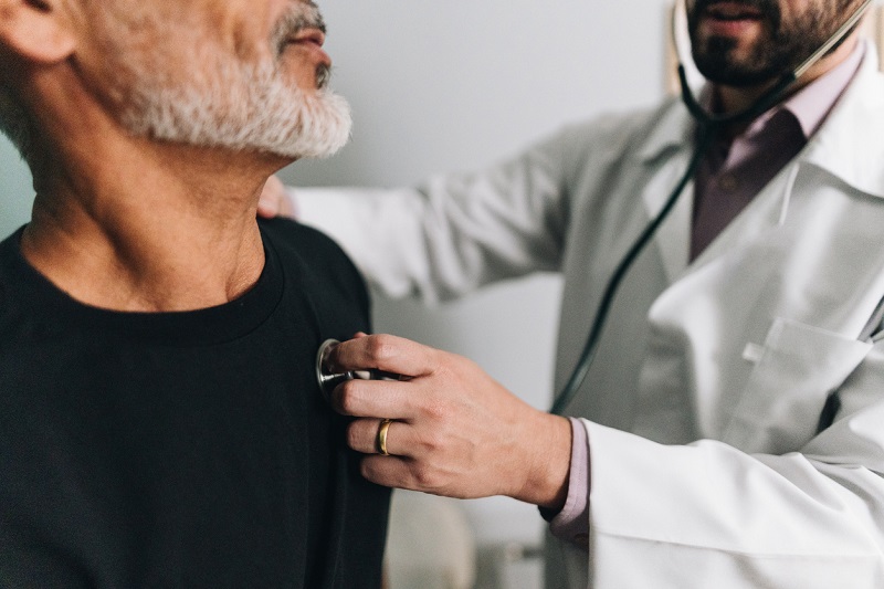 Doctor using a stethoscope to listen to a patient's heart.
