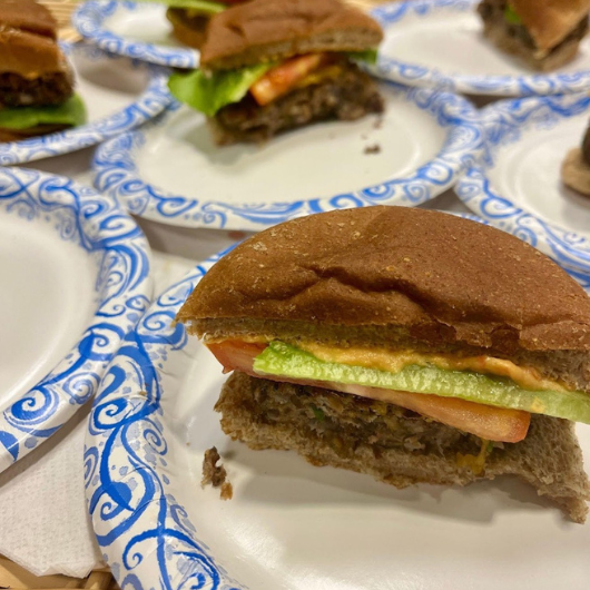 A black bean and farro vegetable burger is shown on a paper plate.