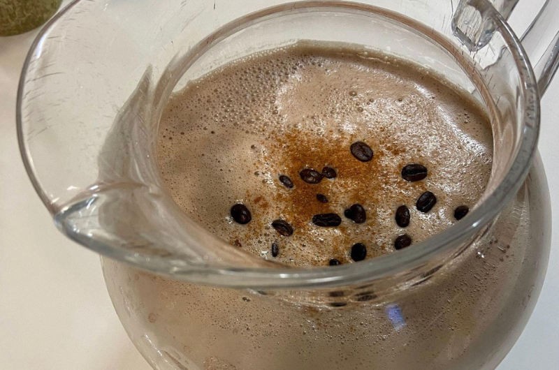 Top-down view of a Tahini coffee smoothie in a large glass pitcher.