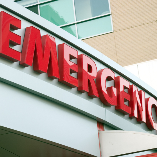 Large red emergency sign on a hospital entrance.