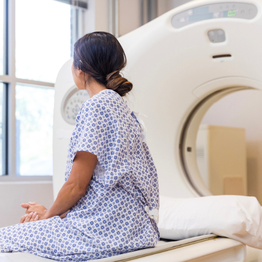 Female physician listens to the lungs of a female senior patient with a stethoscope.