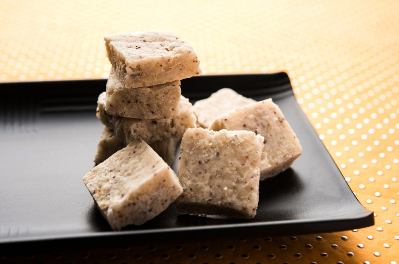 Fresh coconut Burfi served in a bowl or plate over a decorative background.