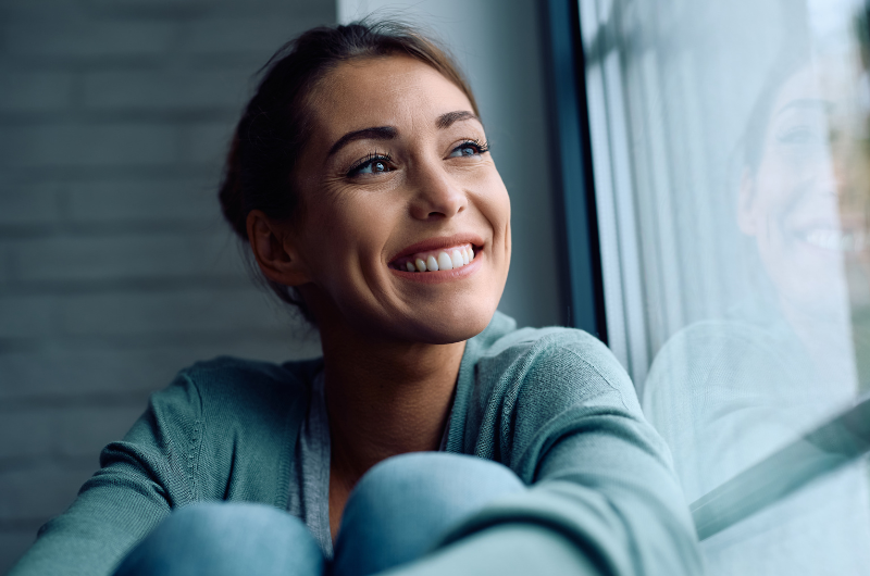 Brunette woman smiles while outsmarting her New Year’s resolutions.