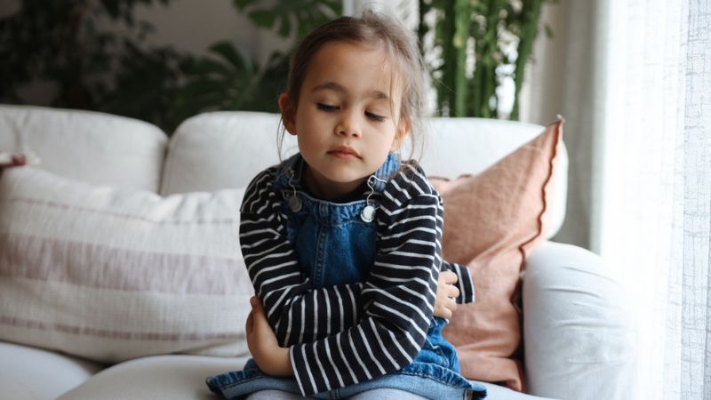 young child holding stomach in discomfort