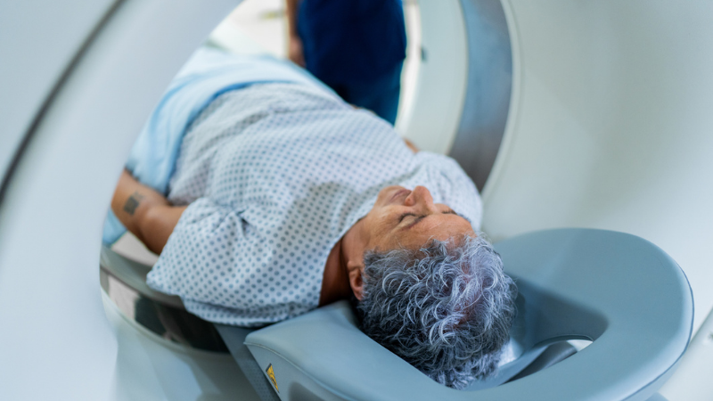 Senior patient woman during magnetic resonance exam at hospital.