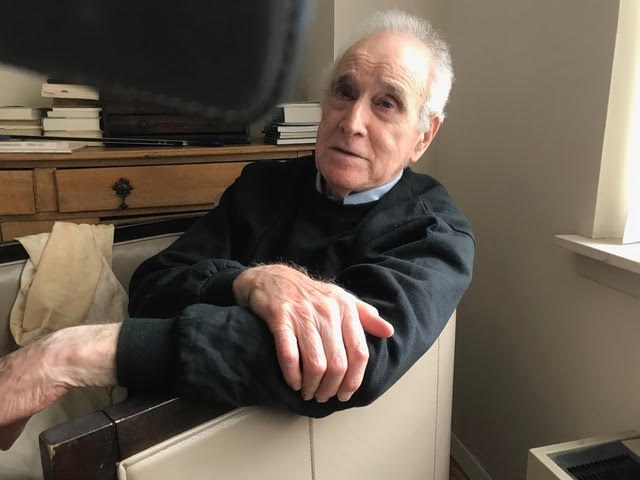 patient Donald Kuspit sitting in a chair in his office