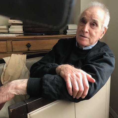 patient Donald Kuspit sitting in a chair in his office