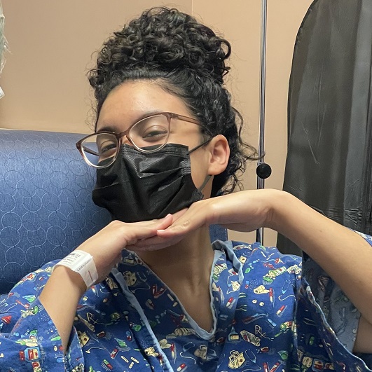 Young patient smiling with a mask on after ACL surgery.