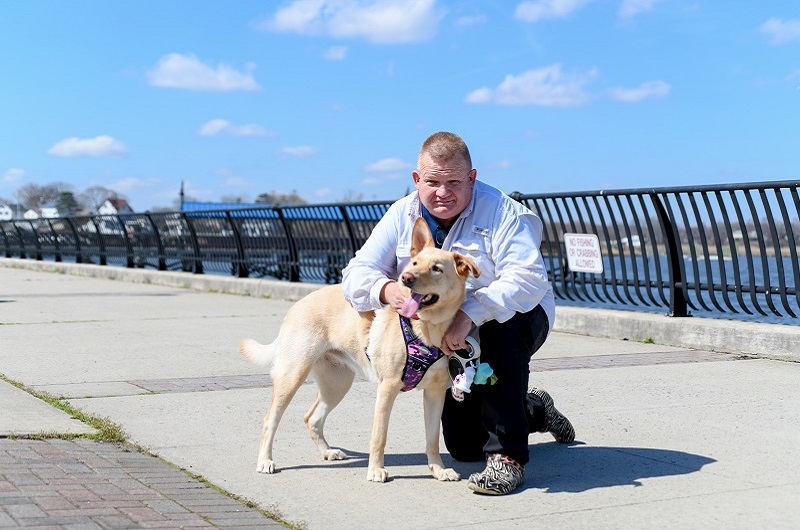 A man with his dog hanging out by the water