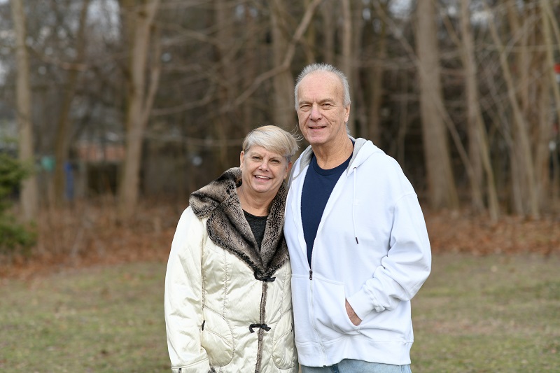 Michael Podolla and wife standing outside, smiling