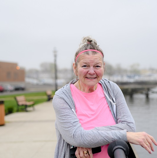 Linda Shorafa standing by the waterway, smiling.