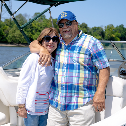 Patient Tomas Marrero and wife Eva, smiling on a boat.
