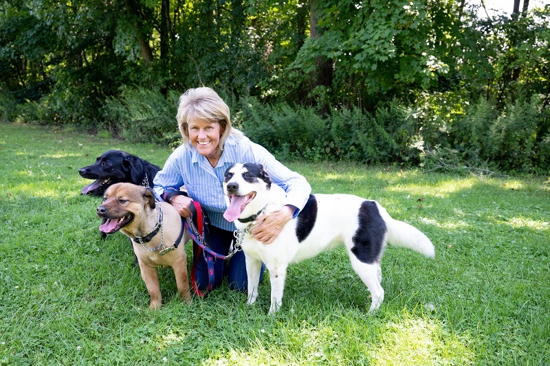 Lisa Hahn hugging her dogs outside, while on a walk.