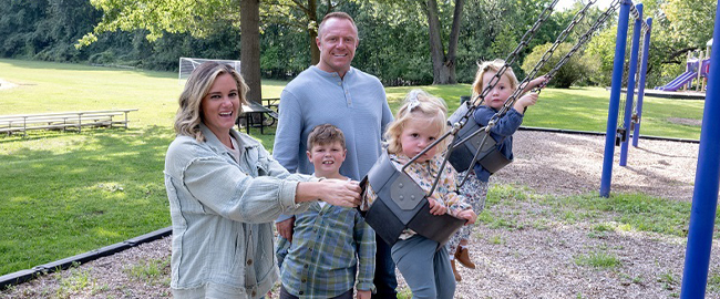 Trista Harper pushing her daughter on a swingset surrounded by her husband and two other children