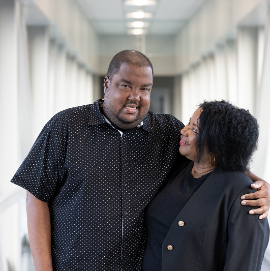 Dave Ferguson standing, embracing a loved one and smiling.