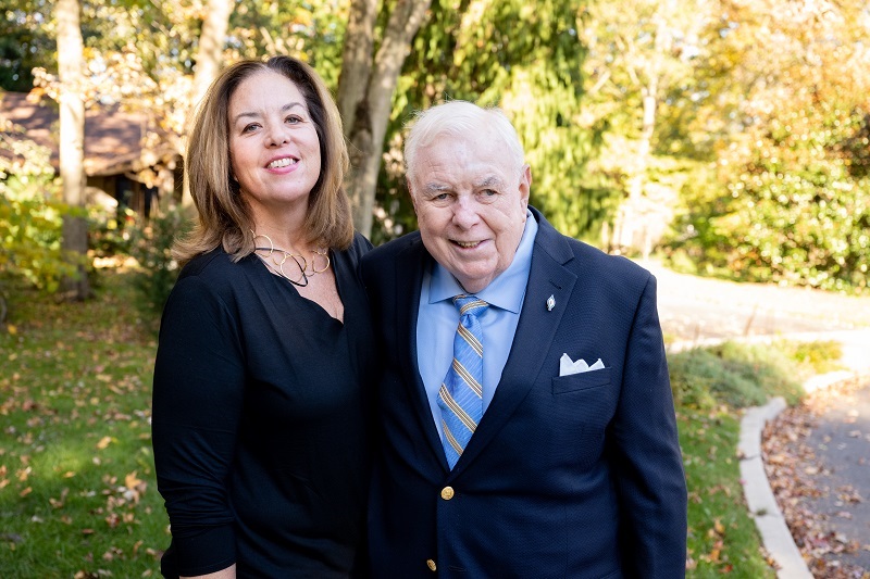 Ann Kushmick and her father, Eugene McAnuff, smiling and standing outside on a warm day.
