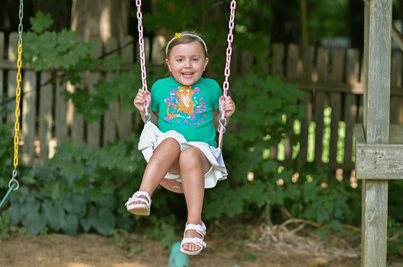 A little girl laughs and smiles at the camera