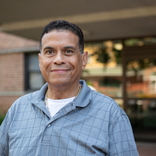 Stroke rehabilitation patient Luis Villa smiles at the camera.